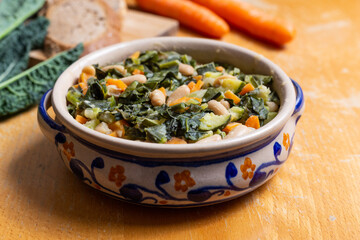 Black cabbage and bean soup on a wooden background Excellent for a healthy and vegan dinner.