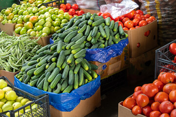 Close up there are many different vegetables on the market. Tomatoes, cucumbers, beans at the vegetable market