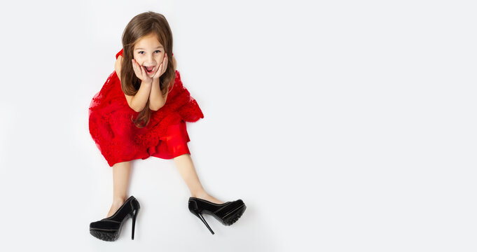 sale. stylish little child girl in elegant dress and oversized mother's shoes on white background. daughter wants to be like mom. Little Princess. copy space