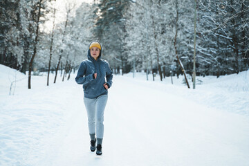 Woman during her jogging workout during winter and snowy day
