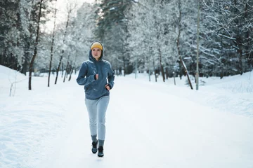 Ingelijste posters Woman during her jogging workout during winter and snowy day © blackday