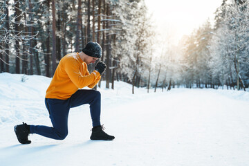 Fototapeta na wymiar Athletic man doing lunges during his calisthenics winter workout in snowy park