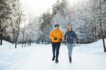 Sportive couple during winter jogging in city park