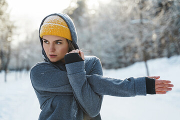 Young athletic woman warming up before her winter workout