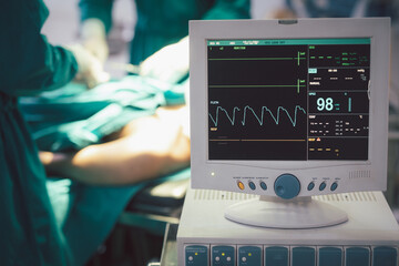 Monitor screen for a medical defibrillator or emergency heart pump, showing vital signs, heart rate, slow beating pulse of a dying coma patient in a hospital ICU room