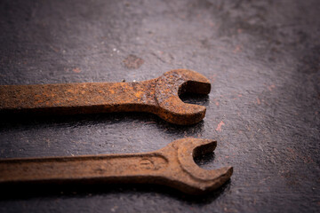 Old rusty wrenches on a dark background
