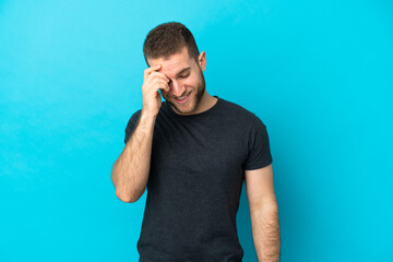 Young handsome caucasian man isolated on blue background laughing