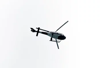 Poster Helicopter Flying in the sky on a white background for design as a security concept and surveillance © Vera