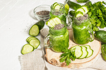 Green smoothie with cucumber in a glass jar. Fresh ripe vegetables, greens, and chia seeds