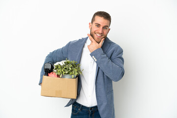 Young caucasian making a move while picking up a box full of things isolated on white background...
