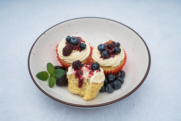 cupcake with berries on a plate on a marble background