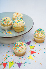 cupcakes with sprinkles on a plate decorated for a birthday