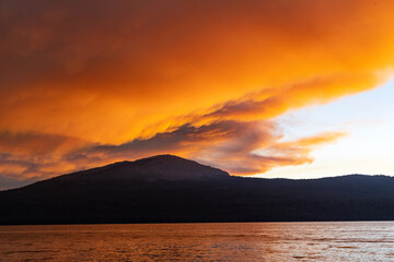 Fototapeta na wymiar Sunset and smoke over mountain and water