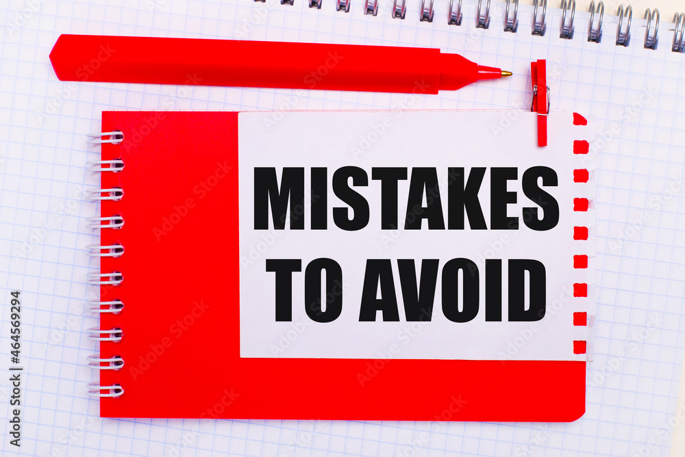 Poster on a white notepad, a red pen, a red notepad and a white sheet of paper with the text mistakes to av