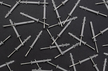 Screws with dowels as abstract industrial background. Top view.