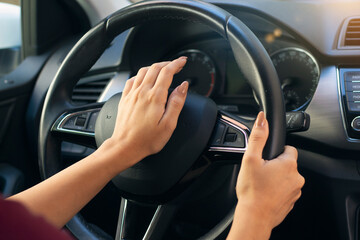 Close up of woman hand pressing the horn button while driving a car. aggressive driver using horn