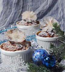 baked muffins in ceramic molds with christmas decorations side view on white textured background closeup. Selective focus