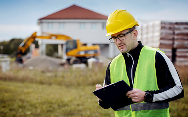 Fototapeta premium Technician making inspection on the construction site and taking a notes