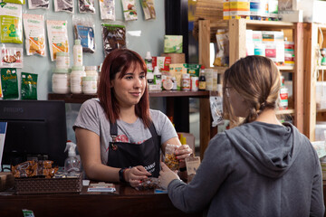 Clienta se acerca al mostrador donde la cajera le muestra los productos y los precios