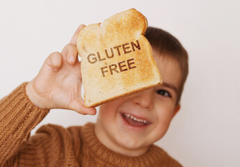 Preschool boy with toasted bread without gluten. Healthy food. Gluten intolerance by children.