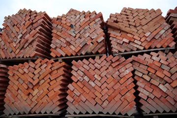 Obraz na płótnie Canvas Stacks of red bricks at outdoor construction supermarket
