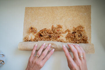 Top view of female hand rolling a delicious apple strudel