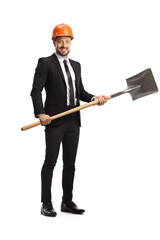 Full length portrait of a businessman investor with a hardhat holding a shovel