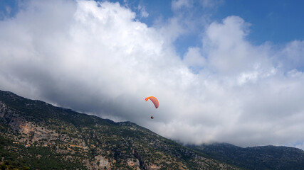 a paraglider in a cloudy sky