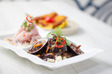 Duo of Peruvian ceviche, black shells and classic fish ceviche.
