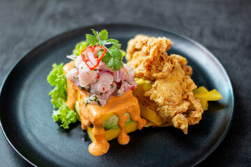 Causa acevichada, accompanied by fried fish.
