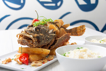 Crispy dorado fish, accompanied by fried yuccas with sauce.
