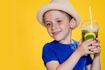 Portrait of a beautiful boy. Happy child. European boy in a hat, summer t-shirt with lemonade. Summer, vacation, vacation, sun, heat, sea, beach. Face for advertising.