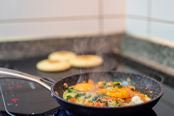 Cooking vegetables with eggs and arepas