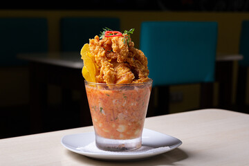 Spicy tiger milk accompanied by pork rinds.