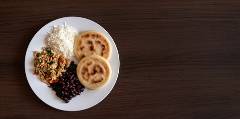Venezuelan breakfast with arepa, white cheese, eggs and black beans