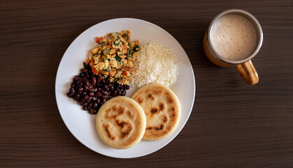 Venezuelan breakfast with arepa, white cheese, eggs and black beans