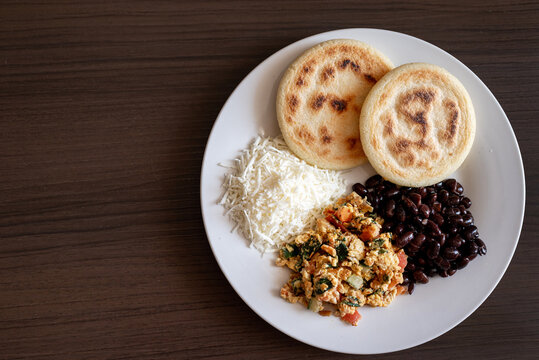 Venezuelan breakfast with arepa, white cheese, eggs and black beans