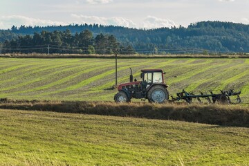 Plowing a field. Tractor with a plow. Farming in the countryside. Autumn work on the farm in Czech Republic.