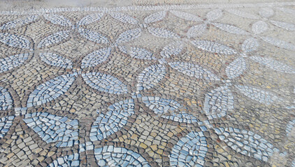 Ancient mosaic covering the ground laid out with pieces of stones in a neat pattern