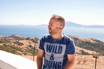 Shot of a Caucasian man in a blue shirt at Mirador del Estrecho in Tarifa, Cadiz, Andalusia, Spain