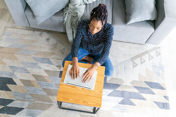 Beautiful young black woman has a zoom call or works in from laptop online