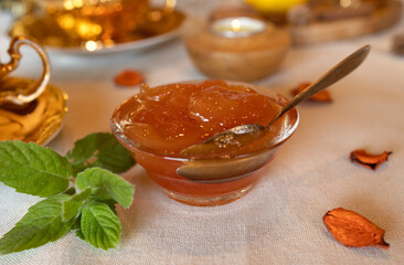 Transparent rosette bowl with golden pear jam, close-up, selective focus