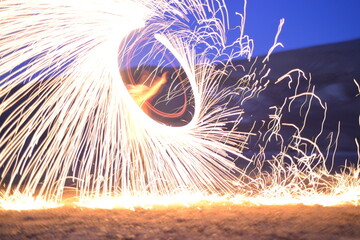 Iron wool circle drawing light fireworks. Burning Steel Wool spinning, Trajectories of burning sparks at night. Movement light effect, steel wool fire hoop. long exposure light painting, Pyrotechnic