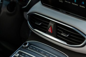 Red triangle hazard light button on car dashboard. Car media buttons dashboard. Detail of a modern car controllers.