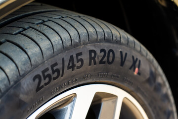 Close up view of tire with tire width, height and wheel diameter designation. Tire size types labels.