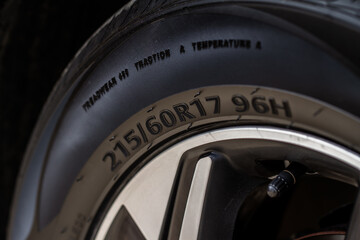 Close up view of tire with tire width, height and wheel diameter designation. Tire size types labels.