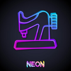 Glowing neon line Sewing machine icon isolated on black background. Vector
