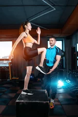 Poster athlete female has exercising lunges on step box with personal trainer in gym © goami