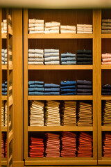 Multiple male polos and shirts for sale at the famshionable store - arranged by colours and sizes