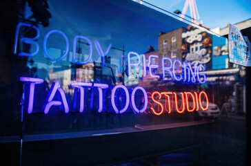 Neon sign in central London with Body Piercing Tattoo Studio signage